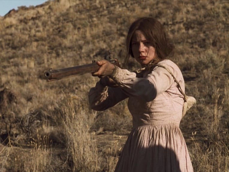Emily Tetherow (Michelle Williams) has a determined look on her face as she aims her rifle in Meek's Cutoff
